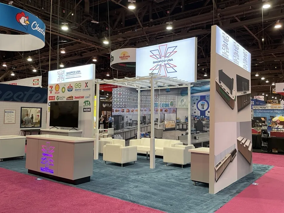 Shopco USA custom exhibit with illuminated overhead brand architecture