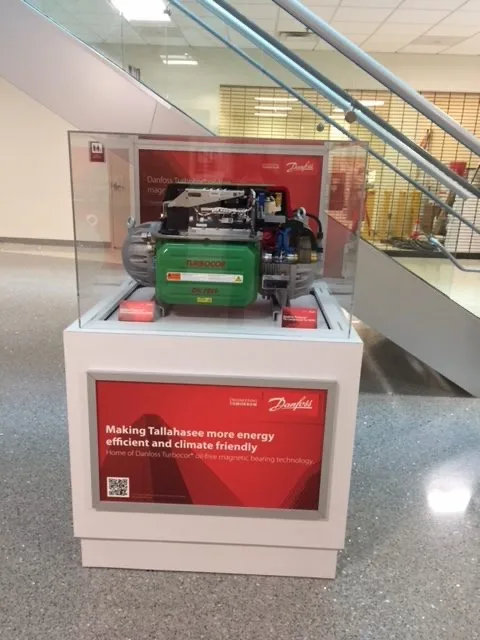 Compact exhibit with large-format wall graphics and a branded counter