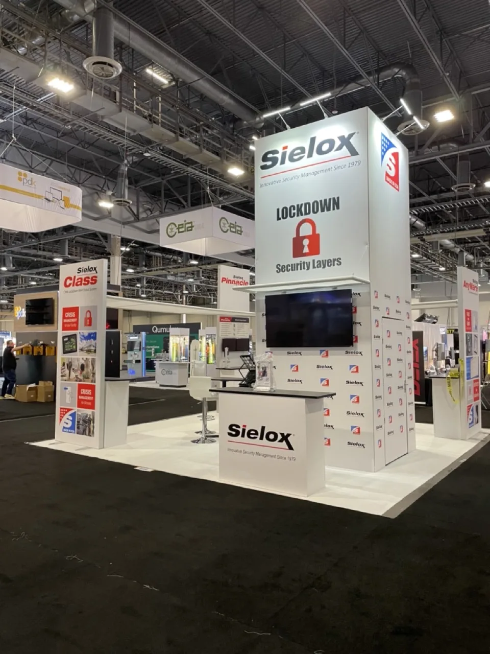 Sielox exhibit with white display walls and overhead signage